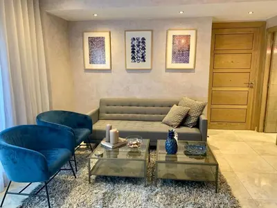 a living room with a couch and two blue chairs at #10 Racine triangle d or near aindiab in Casablanca