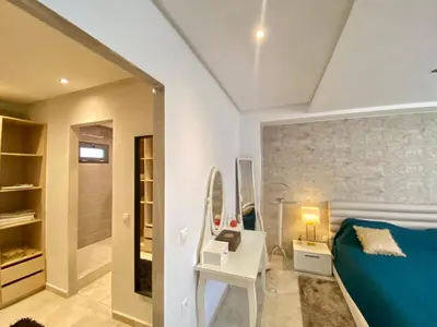 a bedroom with a blue bed and a mirror at #10 Racine triangle d or near aindiab in Casablanca