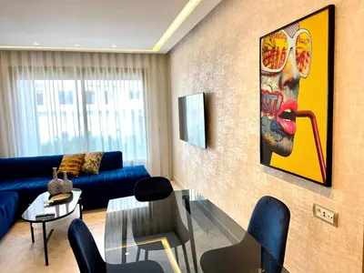 a living room with a blue couch and a glass table at Anfa Living 11 - Classy & Élégant near the Sea in Casablanca