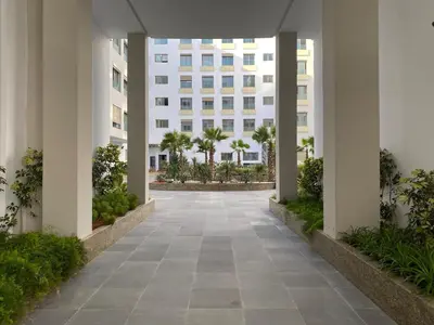 a walkway leading to a building with palm trees at Anfa Living 11 - Classy & Élégant near the Sea in Casablanca