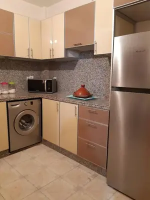 a kitchen with a stainless steel refrigerator and a dishwasher at Les Appartements de Massira in Temara