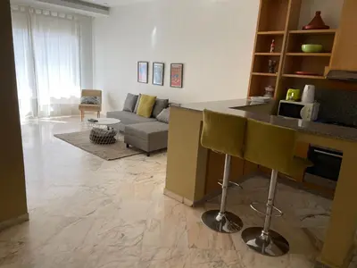 a kitchen and living room with a couch and a counter at Airport to Comme à la maison 2 in Derroua