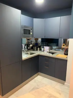 a kitchen with gray cabinets and a microwave at Luxurious Appart near tramway #fibre optique in Casablanca