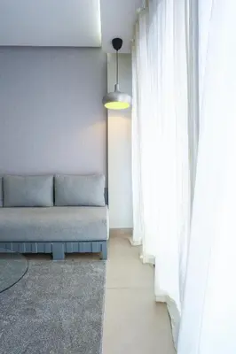 a couch sitting in a room with white curtains at #13 Fresh Appart in new residence in Casablanca