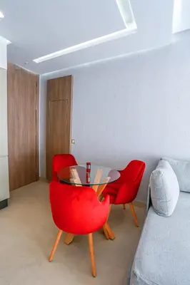 a dining room with red chairs and a glass table at #13 Fresh Appart in new residence in Casablanca