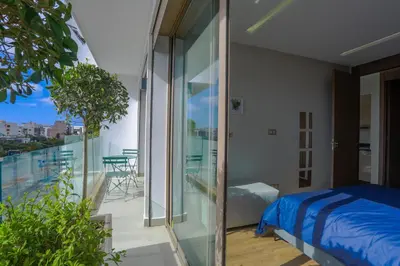 a bedroom with a bed and a balcony with a view at #34 New Flat in new Garden Residence in Casablanca
