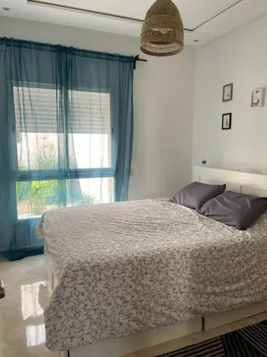a bedroom with a large bed with a window at Appartement vue piscine bien équipé et bien ensoleillé in Casablanca