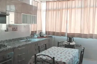 a kitchen with a table and two chairs in it at Grand Appartement à 5 min de la mer et de la mosqué hassan II de Casablanca in Casablanca