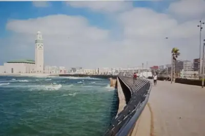 a bridge over a body of water with a lighthouse at Grand Appartement à 5 min de la mer et de la mosqué hassan II de Casablanca in Casablanca