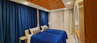 a bedroom with a blue bed and blue curtains at RABAT Residence - OCEAN STAY in Rabat