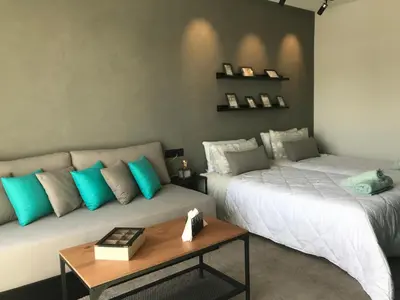 two beds in a room with a couch and a table at RABAT Residence - OCEAN STAY in Rabat