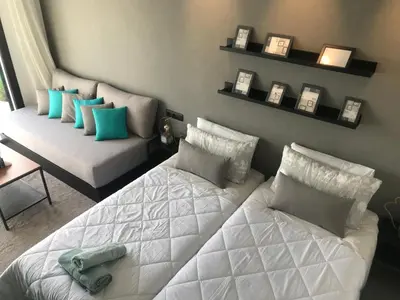 a bedroom with two beds and a couch and shelves at RABAT Residence - OCEAN STAY in Rabat