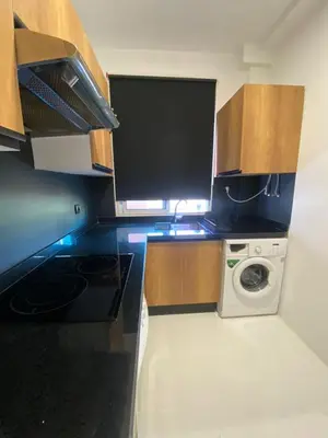 a kitchen with a stove and a washing machine at RABAT Residence - OCEAN STAY in Rabat