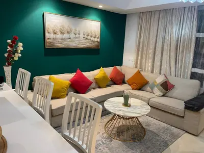 a living room with a couch with colorful pillows at Appartement Anfa Park casa finance City CFC in Casablanca