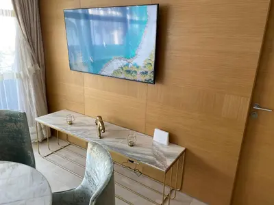 a room with a table and a television on a wall at Appartement Anfa Park casa finance City CFC in Casablanca