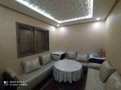 a room with a couch with a table and a window at Appartement à Bouznika prêt du plage Dahomey, plage bouznika, Bahia beach in Bouznika