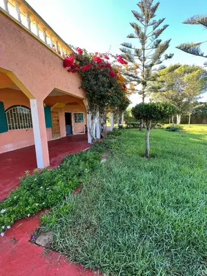 a building with flowers on the side of it at Atlantic Vacation villa in Dar Oulad Hajj Kassem