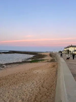 a person walking a dog on the beach at Havre de paix au BahiaGolf Beach, Résidence Front Mer in Bouznika