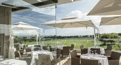 a restaurant with tables and umbrellas with a view at Havre de paix au BahiaGolf Beach, Résidence Front Mer in Bouznika