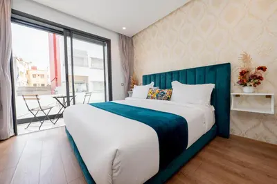 a bedroom with a large bed and a large window at Family Aparthotel in Casablanca