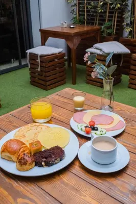 a wooden table topped with plates of food and drinks at Family Aparthotel in Casablanca