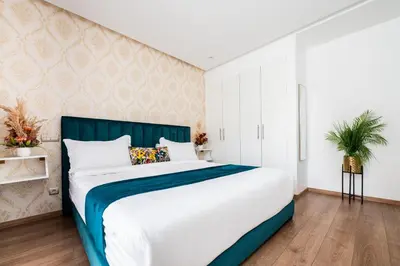 a bedroom with a large bed with a blue headboard at Family Aparthotel in Casablanca