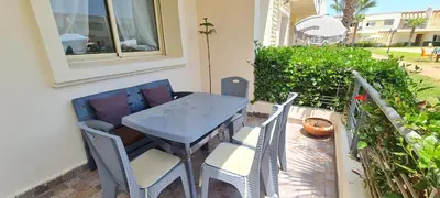 a blue table and chairs on a patio at Bel appartement Savannah Beach in Sidi Rahal