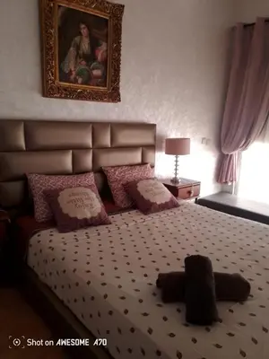 a bedroom with a large bed with pink pillows at Villa avec piscine privée près de Casablanca Maroc in Dar Bouazza