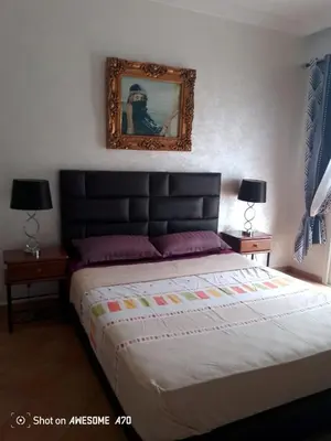 a bedroom with a large bed and two lamps at Villa avec piscine privée près de Casablanca Maroc in Dar Bouazza
