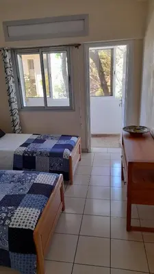 a room with two beds and a desk and two windows at Adarissa House in Rabat