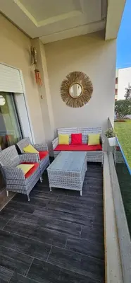 a patio with couches and a table and a mirror at Bel Appartement à AMWAJ Sidi rahal in Casablanca