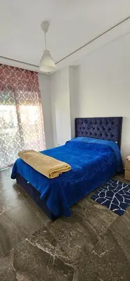 a bedroom with a blue bed with a blue blanket at Bel Appartement à AMWAJ Sidi rahal in Casablanca