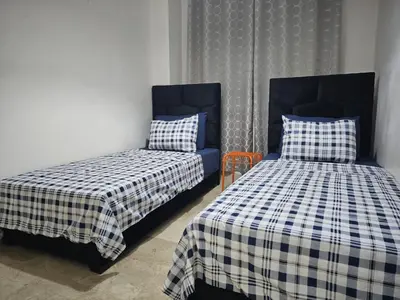 a bedroom with two beds and a blue chair at Luxury Spacious Apartment Midtown Casablanca in Casablanca
