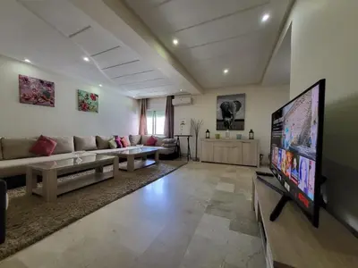 a living room with a couch and a flat screen tv at Luxury Spacious Apartment Midtown Casablanca in Casablanca