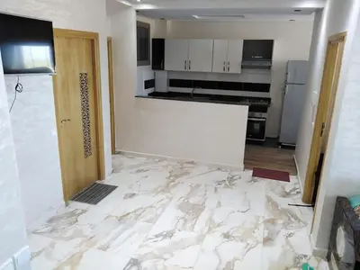 a kitchen being remodeled with a marble floor at Appartement bien situé Dahomey city . Bahia beach in Bouznika
