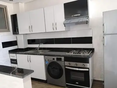 a kitchen with a stove and a washing machine at Appartement bien situé Dahomey city . Bahia beach in Bouznika