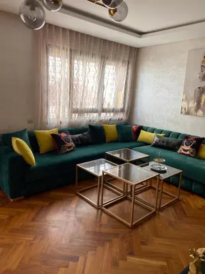 a living room with a green couch and two tables at Casa finance city apartment in Casablanca