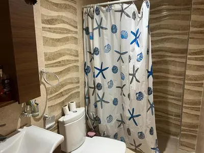 a bathroom with a shower curtain with a toilet at Bel appart à Hacienda Beach Sidi Rahal in Sidi Rahal