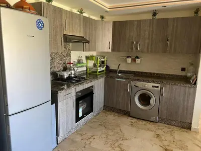 a kitchen with a refrigerator and a washing machine at Bel appart à Hacienda Beach Sidi Rahal in Sidi Rahal