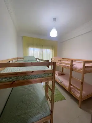 a room with three bunk beds in it at Superbe appartement en résidence avec piscine in Sidi Rahal