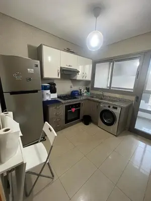 a kitchen with a stainless steel refrigerator and a dishwasher at Superbe appartement en résidence avec piscine in Sidi Rahal
