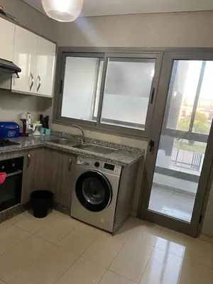 a kitchen with a washing machine next to a window at Superbe appartement en résidence avec piscine in Sidi Rahal