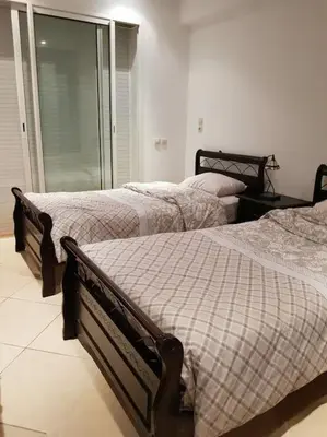 a bedroom with two beds and a window at Sidi Rahal , Residence Garden Beach 2 in Sidi Rahal