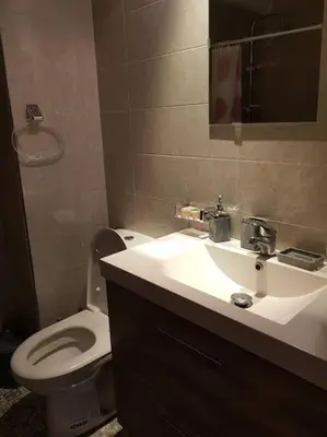 a bathroom with a white toilet and a sink at Sidi Rahal , Residence Garden Beach 2 in Sidi Rahal
