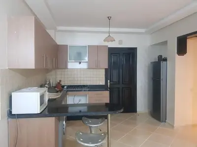 a kitchen with a counter with a microwave and a refrigerator at Sidi Rahal , Residence Garden Beach 2 in Sidi Rahal