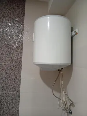 a white water tank on a wall in a bathroom at luxu appart siesta beach resort in Mohammedia