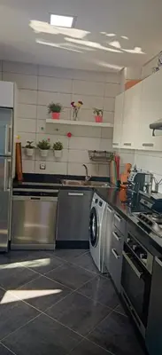a kitchen with a washing machine in the middle at luxu appart siesta beach resort in Mohammedia