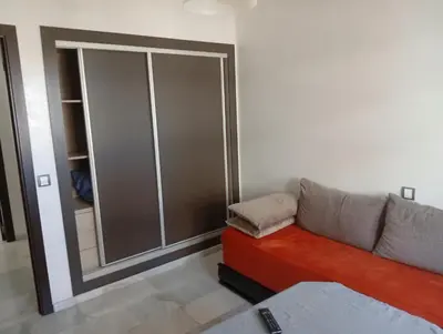 a living room with a couch and a closet at luxu appart siesta beach resort in Mohammedia