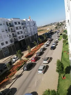 a group of cars parked on a street with buildings at Appartement Résidence fermée in Casablanca