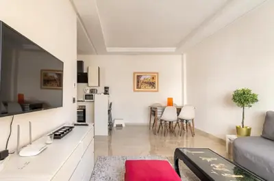 a white living room with a couch and a table at SUITE APPARTEMENT BOURGOGNE 2 pièces in Casablanca